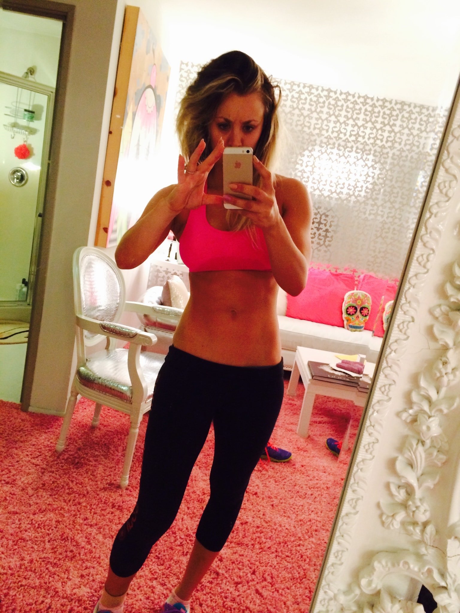 private photo of kaley cuoco taking a mirror pic in bright pink sports bra